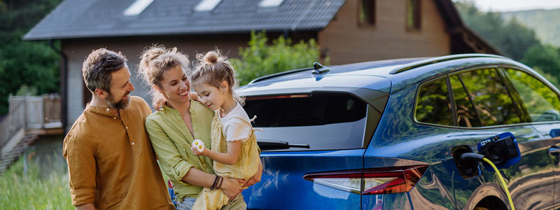 family-standing-beside-electric-vehicle.jpg